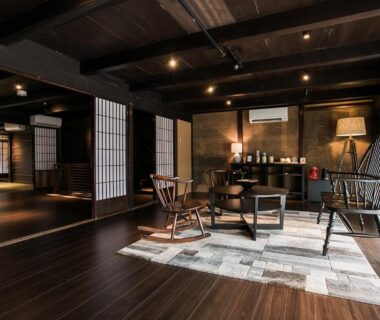 Wood-floored lounge with shoji screens, low wooden chairs and exposed beams at Takeda Castle Town Hotel, Hyōgo
