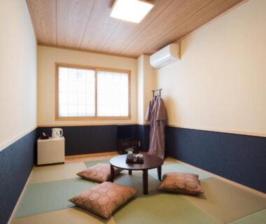Tatami room with low table and cushions at Ebisu Ryokan in Kyoto