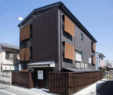 Three-story wooden exterior with wooden screens and gated entrance at Ebisu Ryokan in Kyoto, Kansai