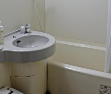 Small bathtub and sink with shower curtain in Eboshiso guest bathroom, Iwate