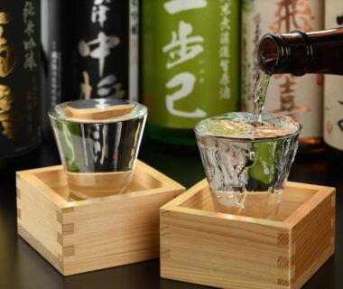 Glass sake cups in wooden masu boxes with bottles at Eirakukan ryokan in Fukushima