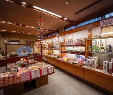 Souvenir shop interior at Eirakukan with local snacks, sake bottles, wrapped gifts and wooden display shelves