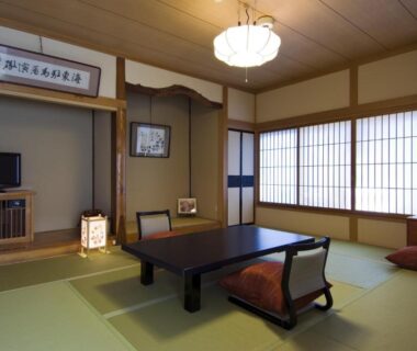 Tatami room with low table, shoji screens and tokonoma at Ekinariya Ryokan in Gunma