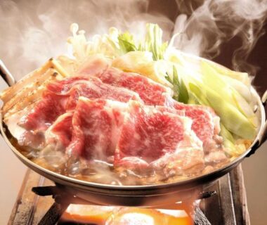 Steaming hot pot with sliced beef and vegetables on tabletop stove at Ekinariya Ryokan, Gunma