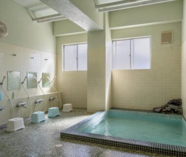 Tiled indoor communal bath with stools and shower heads at Elan Hotel Lake Nojiri, Nagano