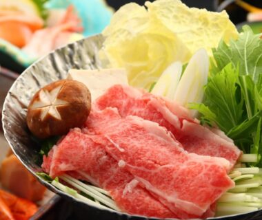 Thin-sliced marbled beef with shiitake mushroom and assorted vegetables in a metal hotpot bowl