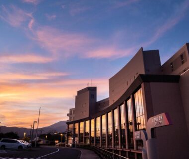 Curved glass facade and entrance of Enakyo Onsen Hotel Yuzuriha at sunset in Gifu Chubu
