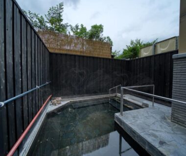Wooden-fenced outdoor onsen bath at Enokiya Ryokan, Ōita, Kyūshū, Japan