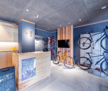 Modern reception desk with wall-mounted bicycles, lobby at Enokiya Ryokan in Oita, Kyushu