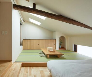 Loft tatami area with low table, futon beds and exposed wooden beams at Enso Machiya, Kyoto