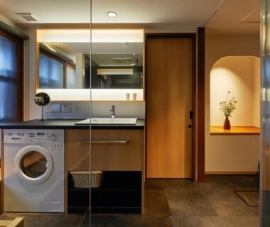 Modern washer, sink and mirror with wooden cabinetry and glass partition at Enso Machiya, Kyoto