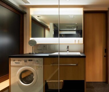 Compact laundry area with sink, mirror and washing machine at Enso Machiya in Kyoto, Kansai, Japan