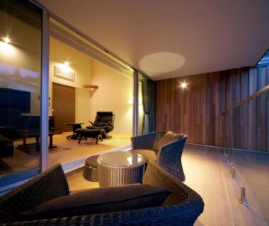 Wicker balcony seating and glass railing beside sliding glass doors into a lounge at Four Seasons Yuzawa Quattro, Niigata