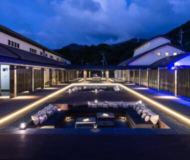 Illuminated sunken onsen pools on wooden deck at Fugaku Gunjo in Shizuoka mountain setting