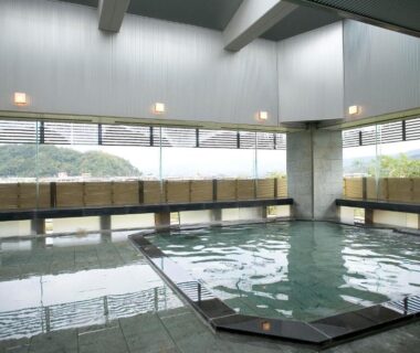 Spacious indoor onsen pool with tiled deck at Fugaku Hanabusa in Shizuoka