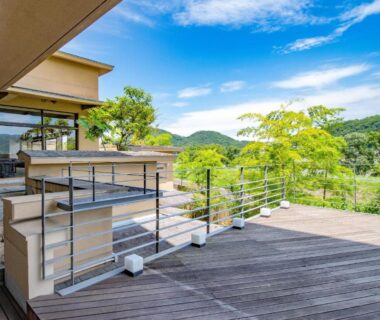 Wooden terrace with glass doors at Fugaku Hanabusa overlooking verdant hills in Shizuoka