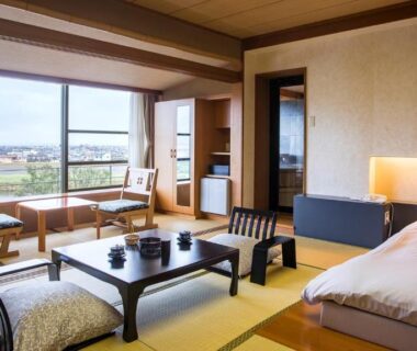 Tatami room with low table, cushions, bed and countryside window view at Fugaku Hanabusa, Shizuoka
