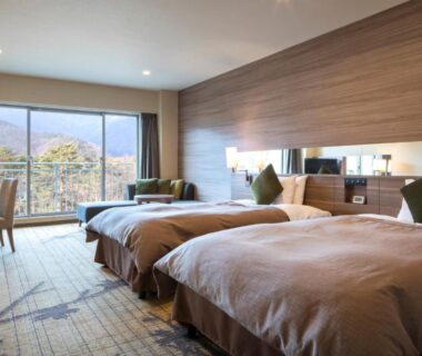 Two beds, large window with distant mountain and trees at Fuji View Hotel, Yamanashi, Chūbu, Japan