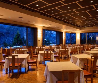 Ryokan dining room with table settings and large windows at Fuji View Hotel in Yamanashi, Chūbu, Japan