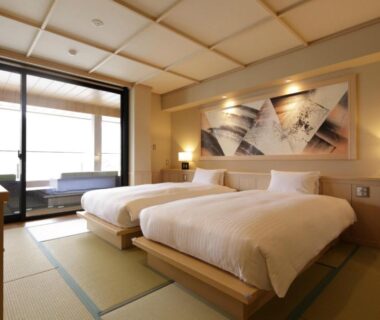 Twin beds on tatami with shoji screens and sliding glass doors at Fujikawaguchiko Onsen Konanso, Yamanashi