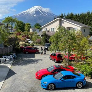 Ryokan courtyard at Fujimien with parked sports cars and Mount Fuji rising behind, Yamanashi Chūbu