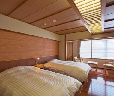 Low twin beds, wooden ceiling and window seating in Fujiya room, Niigata, Chūbu