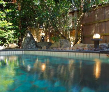 Outdoor tiled onsen bath with wooden fence and greenery at Fujiya in Ishikawa, Chūbu, Japan