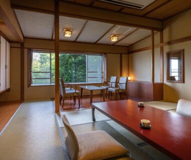 Traditional tatami room with low wooden table, floor cushions, shoji screens and garden view at Fujiya in Niigata