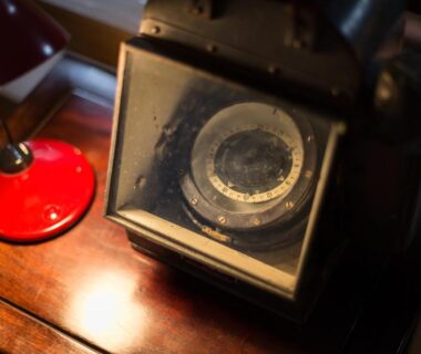 Close-up of vintage camera and red lamp on wooden table at Fujiya, Kumamoto, Kyūshū