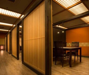 Wood-paneled ryokan corridor with dining alcove and shoji-style partitions at Fujiya in Ishikawa