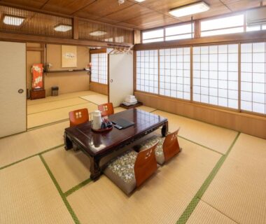Tatami room with low table, zabuton cushions and shoji screens at Fujiya Ryokan, Kyoto