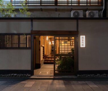 Evening lit ryokan entrance with wooden lattice doors at Fujiya Ryokan in Kyoto
