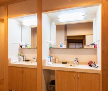 Shared wooden vanity area with two sinks and mirrors at Fujiya Ryokan in Kyoto