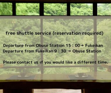 Shuttle schedule notice on interior window with green garden view at Fukeikan Nagano