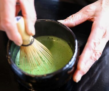 Hands whisking bright green matcha in a chawan at Fukeikan 風景館 Nagano