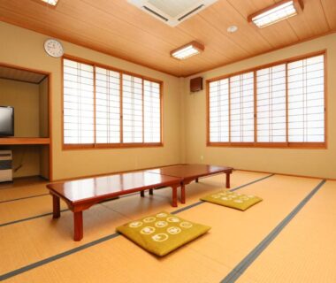 Traditional tatami room with zabuton cushions, shoji screens and television at Fukuichi ryokan in Yamanashi