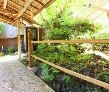 Stone walkway with wooden railing and moss garden at Fukuichi ryokan, Chubu Yamanashi Japan