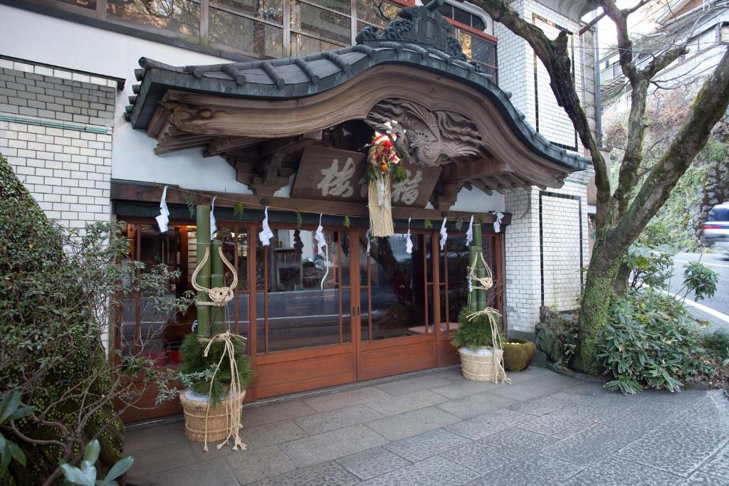 Traditional ryokan entrance Fukuzumiro Kanagawa Carved wooden gable entrance with kadomatsu decorations and sliding doors at Fukuzumiro ryokan in Kanagawa Japan