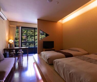 Twin bedroom with wooden flooring, low platform beds and balcony overlooking greenery at Fulsato, Iwate