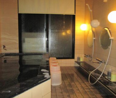 Tiled indoor bathing area with shower stools at Funayado Akitaya in Kanagawa