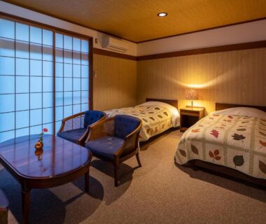 Twin room with shoji screens, low table and chairs, wooden ceiling at Furusato in Gifu