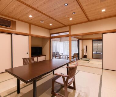 Traditional tatami room with low table, zaisu chairs, sliding doors and balcony at Furuya Ryokan in Shizuoka