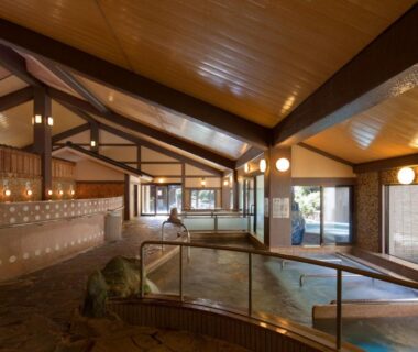Tiled indoor onsen bath with wooden beams, lantern lighting and windows at Furuyu Onsen Oncri, Saga