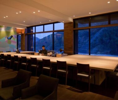Long wooden counter, seating and panoramic windows with mountain view at Furuyu Onsen Oncri in Saga, Kyūshū