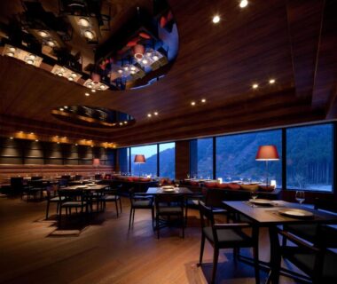 Warm wood dining room with large windows overlooking forested mountains at Furuyu Onsen Oncri in Saga Kyushu