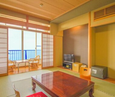 Tatami room with shoji screens, low wooden table and balcony at Futagojimasou in Wakayama