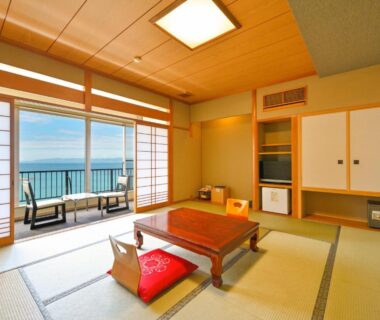 Traditional tatami room with low table, shoji screens and balcony overlooking the sea at Futagojimasou, Wakayama