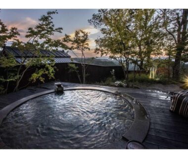 Circular outdoor onsen bath on wooden deck at Gekkoju Kurokawa, Kumamoto, Kyushu