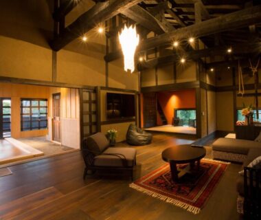 Wooden lounge with sofas, low table, shoji screens and tatami alcove at Gekkoju Kurokawa, Kumamoto