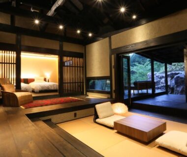 Interior tatami room with low table, futon bed and outdoor wooden bath on veranda, Gekkoju Kurokawa, Kumamoto, Kyushu